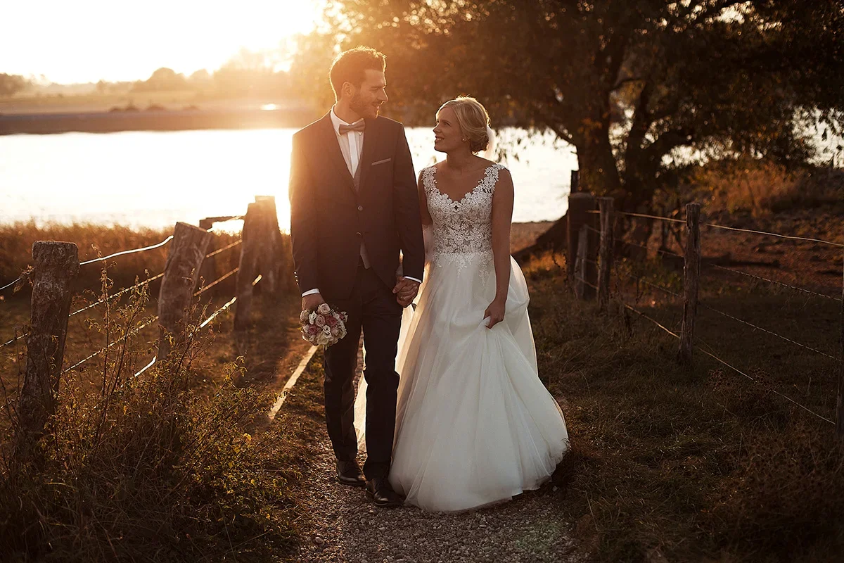 Hochzeitsfotografie NRW – Romantisches Paar spaziert Hand in Hand